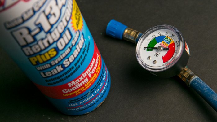 Can of car A/C refrigerant with pressure gauge